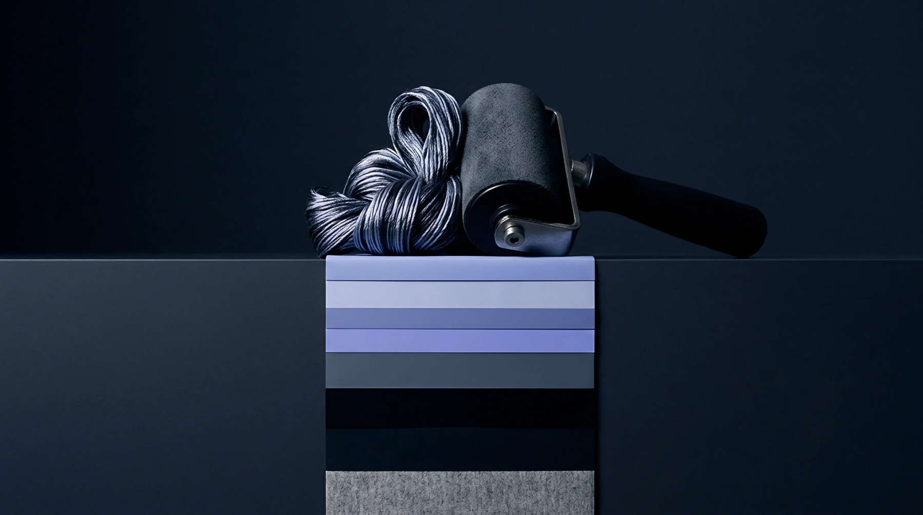 A series of textured fabric color swatches hangs from a dark platform beside a bundled synthetic yarn and a finishing hand roller.